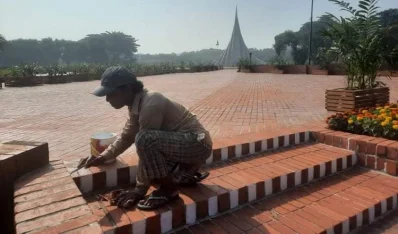 স্মৃতিসৌধ ধোয়ামোছা আর সাজসজ্জায় কাজ করেছেন পরিচ্ছন্নতাকর্মী। ছবি: ইত্তেফাক