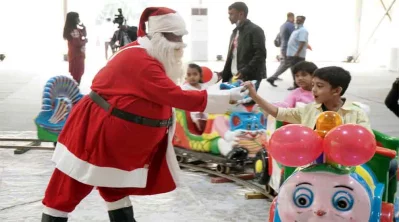 সান্তাক্লোজ সেজে শিশুদের উপহার দেওয়া হচ্ছে।