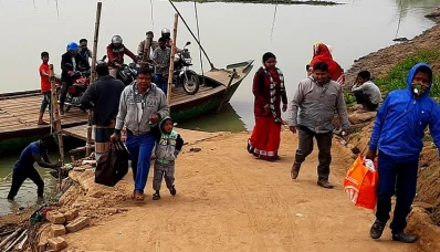 ফেরি বন্ধ থাকায় স্থানীদের ছোট একটি নৌকা দিয়ে নদী পারাপার হতে হচ্ছে।