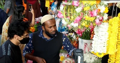 ক্রেতাদের বিভিন্নধরনের ফুল দেখাচ্ছেন এক বিক্রেতা। ছবি: তানভীর আহাম্মেদ