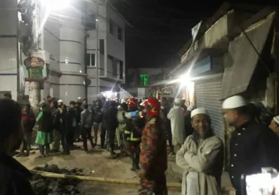 হেলে পড়া ভবনের সামনে উৎসুক জনতার ভিড়।