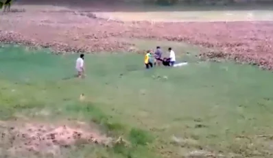 ডোবা থেকে এক শিক্ষার্থীকে তুলে আনা হচ্ছে। সামাজিক যোগাযোগমাধ্যমে ছড়িয়ে পড়া ভিডিও থেকে ছবিটি নেওয়া হয়েছে।