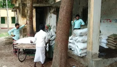 স্থানীয় ডিলারদের ভাড়া করা ভ্যানে সারের বস্তা তুলে দিচ্ছে কার্ডধারী কৃষকরা।