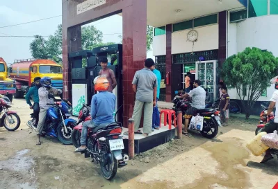 সাপাহারে ফিলিং স্টেশন থেকে তেল নিচ্ছেন মোটরসাইকেলচালকরা।