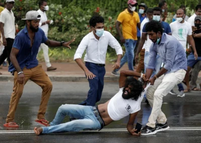 এক বিক্ষোভকারীকে টেনে নিয়ে যাচ্ছে অন্যরা