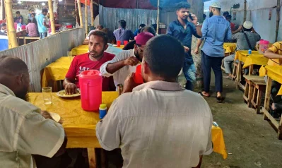 দোকানে খাবার খাচ্ছে মানুষ।
