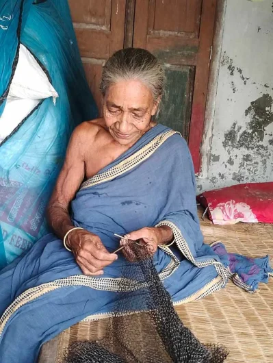 ঘরে বসে জাল বুনছেন ৮০ বছরের বৃদ্ধা খুকু রাণী।