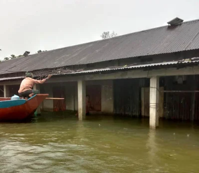 সড়কে বুক সমান পানি। ঘরও প্লাবিত। চলাচল করতে হচ্ছে নৌকায়। ছবি: সংগৃহীত