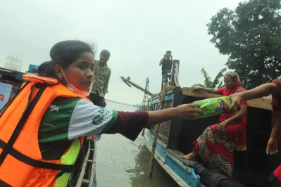 সংগঠনের কর্মীরা বন্যাদুর্গত নারীদের ত্রাণ দিচ্ছেন। ছবি: ইত্তেফাক