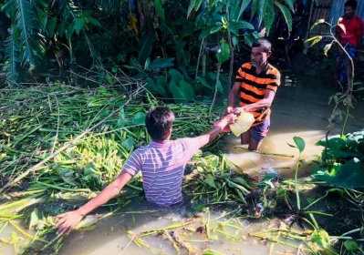 কোমড়সমান পানি মাড়িয়ে বন্যার্তদের জন্য খাবারর ব্যাগ পৌঁছে দিচ্ছেন মনুষ্যত্ব ফাউন্ডেশনের এক সদস্য