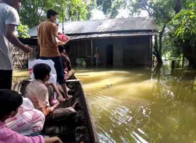 বন্যাকবলিত এলাকায় নৌকায় করে খাদ্যসামগ্রী বিতরণ করছে মনুষ্যত্ব ফাউন্ডেশন