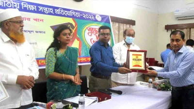 শ্রেষ্ঠ প্রধান শিক্ষকের ক্রেস্ট নিচ্ছেন রেজাউল করিম। ছবি: সংগৃহীত