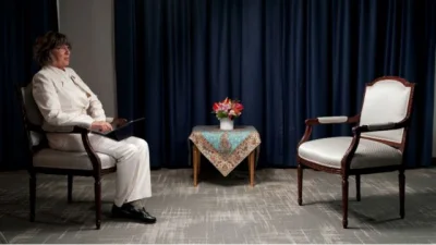 খালি চেয়ারের সামনে বসে একটি ছবি