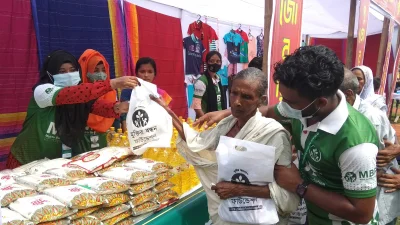 নিত্যপ্রয়োজনীয় সামগ্রী নিচ্ছেন এক নারী। ছবি: ইত্তেফাক