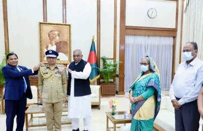 প্রধানমন্ত্রী শেখ হাসিনার উপস্থিতিতে গণভবনে নতুন আইজিপিকে র&zwnj;্যাঙ্ক ব্যাজ পরিয়ে দেন স্বরাষ্ট্রমন্ত্রী ও জননিরাপত্তা বিভাগের সিনিয়র সচিব।ছবি- ফোকাস বাংলা