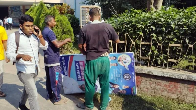 গাছে পেরেক ঠুকে টাঙানো সাইনবোর্ড-বিজ্ঞাপন তুলে ফেলা হচ্ছে। ছবি: ইত্তেফাক