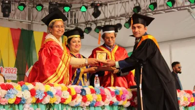 শিক্ষার্থীকে চ্যান্সেলর অ্যাওয়ার্ড তুলে দিচ্ছেন শিক্ষামন্ত্রী।