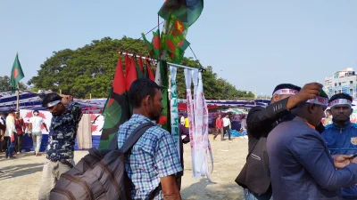 ক্যাম্পের পাশে মনোগ্রাম, পতাকা ও হেড ব্যান্ড বিক্রি করছেন দোকানিরা। ছবি: ইত্তেফাক