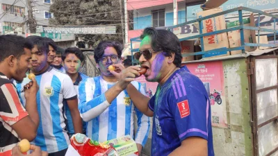 একে অপরকে মিষ্টি খাওয়াচ্ছেন সমর্থকরা। ছবি: ইত্তেফাক