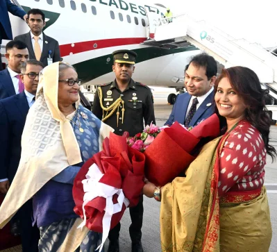 বিমানবন্দরে প্রধানমন্ত্রী শেখ হাসিনাকে ফুল দিয়ে স্বাগত জানাচ্ছেন কাতারে নিযুক্ত বাংলাদেশের রাষ্ট্রদূত মো. নজরুল ইসলাম। ছবি: ফোকাস বাংলা