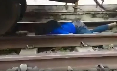 ট্রেনের নিচ শুয়ে আছে কিশোর। ছবি: সংগৃহীত