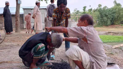 মাটিতে বসে চুল-দাঁড়ি কাটে জীবন-জীবিকা নির্বাহ করেন ফুলবাড়ীর প্রদীপ চন্দ্র শীল ও মনোরঞ্জন চন্দ্র শীল। ছবি: ইত্তেফাক  