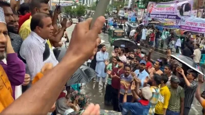 বৃষ্টির মাঝে পানিতে দাঁড়িয়ে নেতা-কর্মীরা স্লোগান দিচ্ছেন। ছবি: ভিডিও থেকে নেওয়া