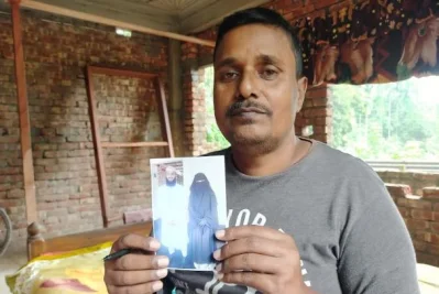 চিকিৎসক ছেলে ও বউমার ছবি হাতে বাবা হেলাল উদ্দিন। ছবি: ইত্তেফাক