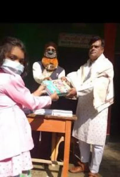 গত জানুয়ারিতে ছাত্রীদের হাতে বই তুলে দিচ্ছেন আসামির আইনজীবী ও বিদ্যালয়ের সভাপতি রবিউল হাসান রতন। ছবি: ইত্তেফাক