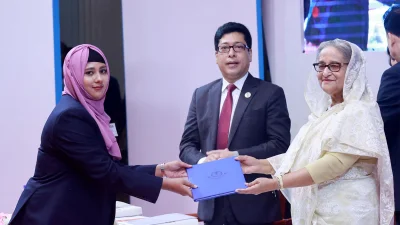 রোববার সকালে রাজধানীর ওসমানী স্মৃতি মিলনায়তনে বিসিএস বুনিয়াদি প্রশিক্ষণ কোর্সের সনদ বিতরণ প্রধানমন্ত্রী শেখ হাসিনা। পাশে ছিলেন জনপ্রশাসন প্রতিমন্ত্রী ও মেহেরপুর-১ আসনের সাংসদ ফরহাদ হোসেন। ছবি: ফোকাস বাংলা