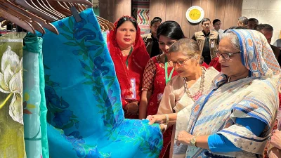 মঙ্গলবার সকালে রাজধানীর ধানমন্ডিতে জয়িতা টাওয়ারের উদ্বোধন শেষে জামদানি শাড়ির দোকান ঘুরে দেখেন প্রধানমন্ত্রী শেখ হাসিনা। এ সময় দোকানের একটি জামদানি শাড়ি নেড়েচেড়ে দেখেন তিনি। তার সঙ্গে ছিলেন ছোট বোন শেখ রেহানা। ছবি: ফোকাস বাংলা
