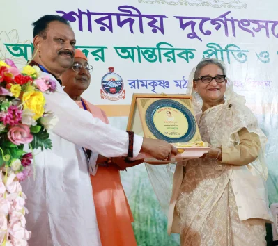 প্রধানমন্ত্রী শেখ হাসিনাকে বই ও ক্রেস্ট উপহার দেওয়া হচ্ছে। ছবি: ফোকাস বাংলা