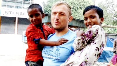 দুই বাঙালি শিশুকে কোলে নিয়েছেন এক রাশিয়ান নাগরিক। ছবি : ইত্তেফাক