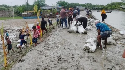 বাঁধ রক্ষার চেষ্টা করছেন স্থানীয়রা। ছবি: সংগৃহীত