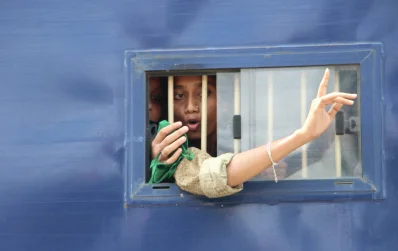 আটক করে নিয়ে যাওয়ার সময় পুলিশের গাড়ির জানালা দিয়ে প্রতিবাদ জানাচ্ছেন এক ছাত্রী | ছবি: ইত্তেফাক