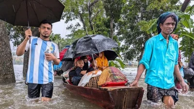 ফেনীতে নৌকায় করে নিরাপদ আশ্রয়ের খোঁজে একটি পরিবার। ছবি: এএফপি