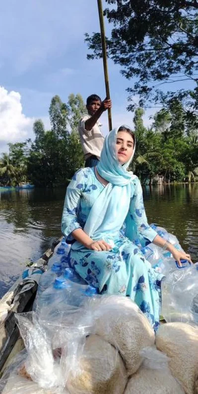 নৌকায় ঘুরে ঘুরে ত্রাণ বিতরণ করছেন বুবলী। ছবি: ফেসবুক থেকে নেওয়া