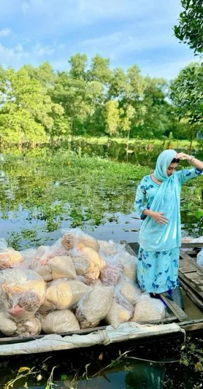 নৌকায় ঘুরে ঘুরে ত্রাণ বিতরণ করছেন বুবলী। ছবি: ফেসবুক থেকে নেওয়া