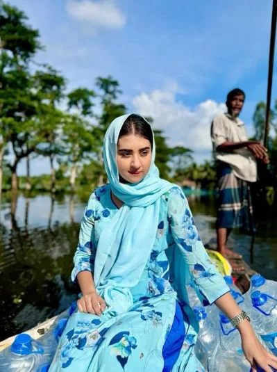 নৌকায় ঘুরে ঘুরে ত্রাণ বিতরণ করছেন বুবলী। ছবি: ফেসবুক থেকে নেওয়া