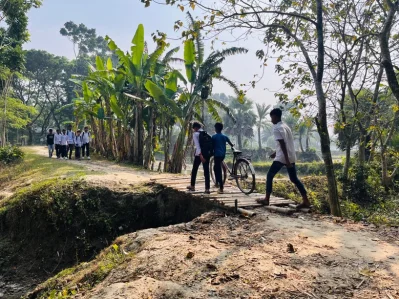 রাস্তা ভেঙে যাওয়ায় বাসের সাঁকো বানিয়ে চলাচল করছে শিক্ষার্থীরা। ছবি: আজিম হোসেন 