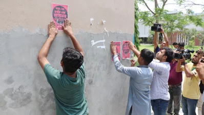 দেওয়ালে উপাচার্যের পদত্যাগ দাবি সম্বলিত পোস্টার সেঁটে দিচ্ছেন আন্দোলনরত শিক্ষার্থীরা। ছবি: ইত্তেফাক 