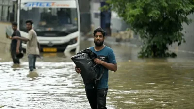 শহরে হাঁটু জলের মধ্য দিয়ে মানুষ হেঁটে যাচ্ছে। ছবি: সংগৃহীত