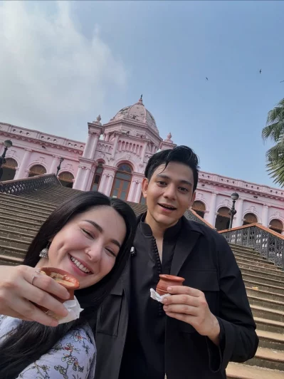 আহসান মঞ্জিলের সামনে বাংলাদেশি জনপ্রিয় ফুডভ্লগার ইফতেখার রাফসানের সঙ্গে মাটির কাপে দুধ চা খাচ্ছেন হানিয়া আমির। ছবি: সংগৃহীত