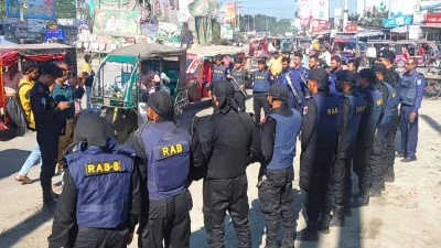 অনাকাঙ্ক্ষিত ঘটনা এড়াতে মাদারীপুর সদরের মোস্তফাপুর মোড়ে আইনশৃঙ্খলা বাহিনী সতর্কত অবস্থান নিয়েছে। ছবি:ইত্তেফাক