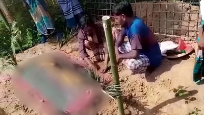 পের কামড়ে মারা যাওয়া নারীকে দাফনের দুই দিন পর কবরের পাশে ঝাড়ফুক করছেন ওঝা