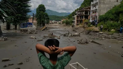 নেপালে বন্যায় ক্ষতিগ্রস্থ এলাকা দেখছে এক কিশোর।
