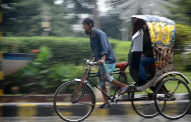 বৃষ্টি থেকে বাঁচতে অনেকেই রিকশায় উঠেছেন। তবে রিকশাচালকদের ঠাই নেই, তারা কখনো মানেন না রোদ-ঝড়-বৃষ্টি। ছবি: ইয়াসিন কবির জয়